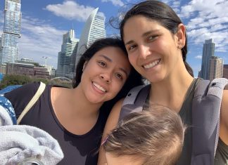 Au Pair Laura and Mom Angie pose in front of Austin's downtown skyline with happy baby in the baby carrier.