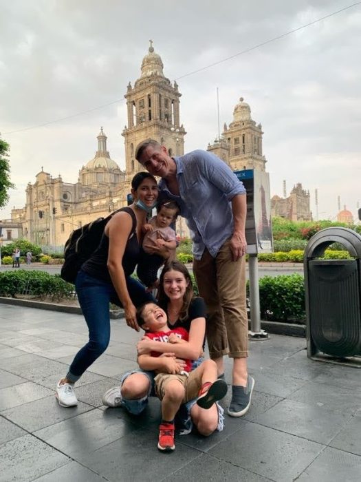 The author's family takes their first post COVID international family trip to Mexico City, posing in front of main cathedral.