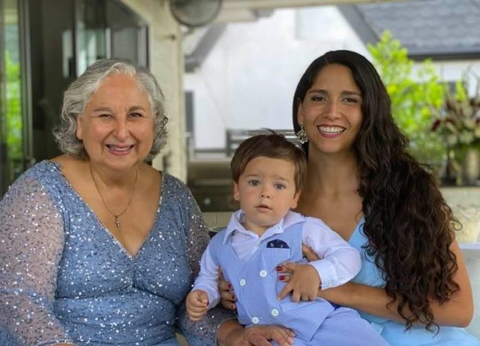 The author and her mother pose with the author's son at her sister's wedding, full curls in display on both.
