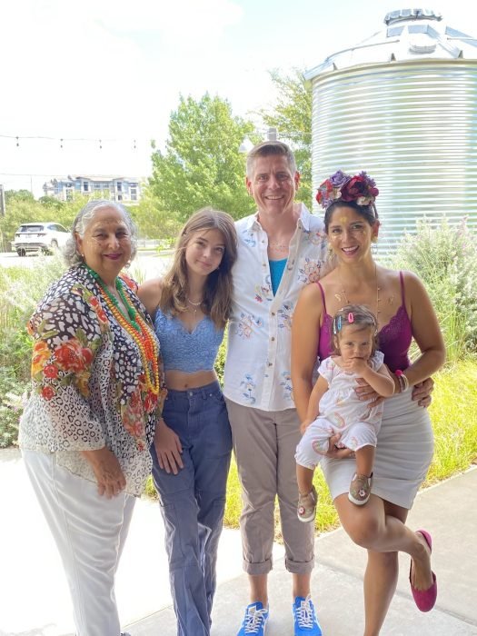 A photo of the author with her mom, husband, step-daughter and baby posing outside of a Drag Brunch to celebrate her birthday. Their colorful clothes and temporary tattoos illustrate how they support her endeavors and celebrations.